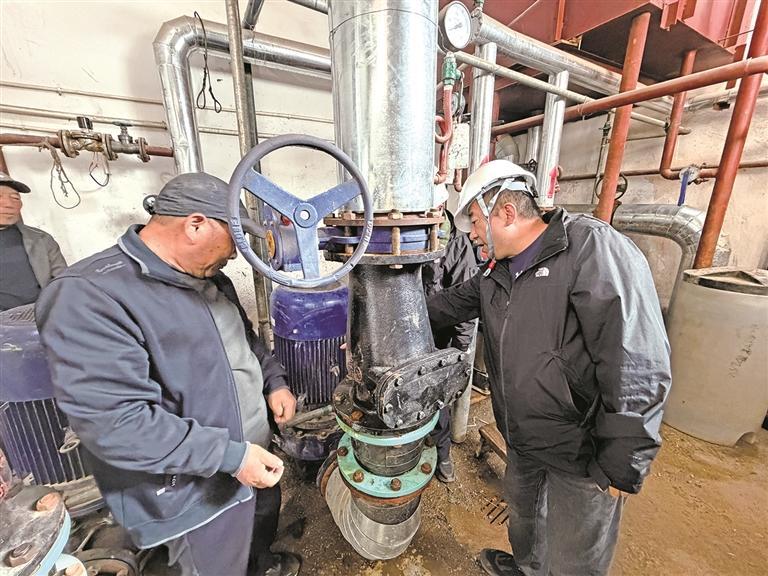 彭家寨东小区锅炉房工作人员检查管道设备
